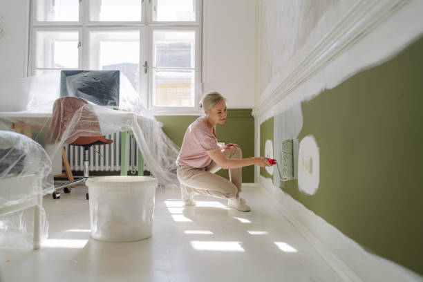 Painter coating interior walls evenly to enhance home appearance instantly.