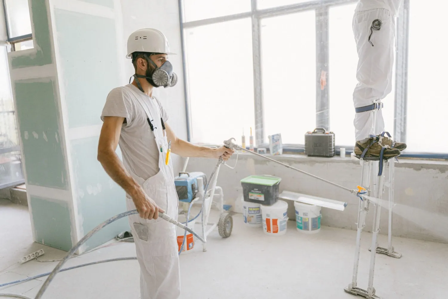 Person applying interior paint to a prepared wall with protected flooring in Marineland, FL.